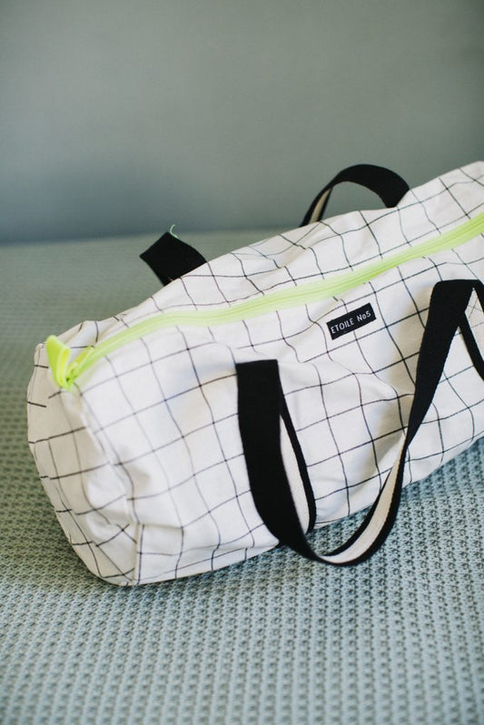 Sports bag for children in white resin-coated cotton with black and fluorine squares